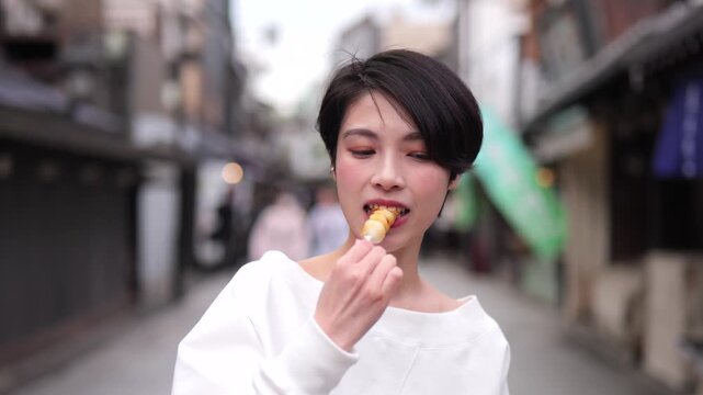 観光地で和菓子を食べる女性のクローズアップ
