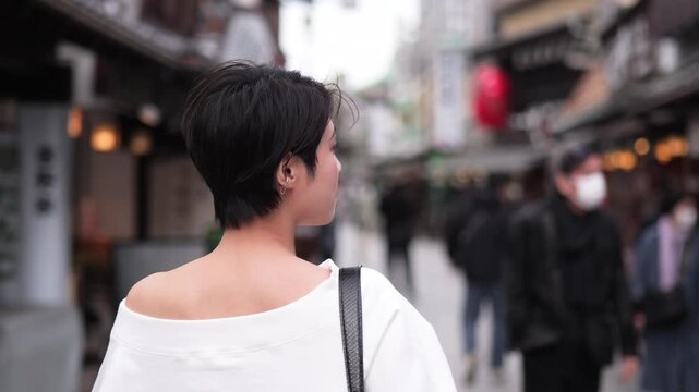 伝統的な観光地を見物する女性の後ろ姿のフォローショット