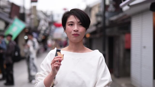 観光地で食べ歩きをする女性のフォローショット