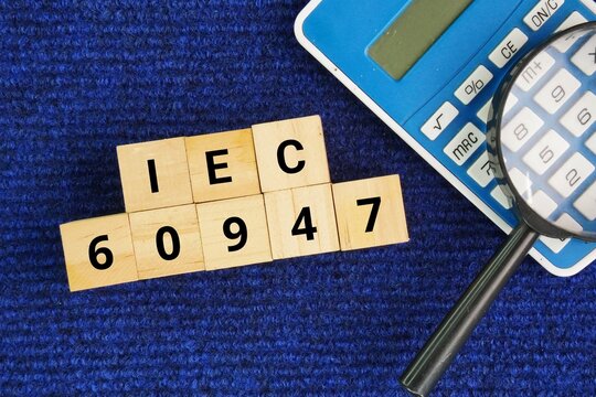 A wooden cube with the words IEC 60947. defines the rules, safety requirements, and testing procedures for low-voltage switchgear and controlgear. It covers industrial-grade devices