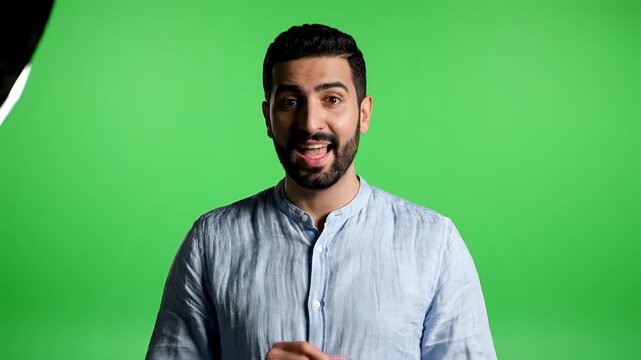Man in Blue Shirt Gesturing on Green Screen Background.