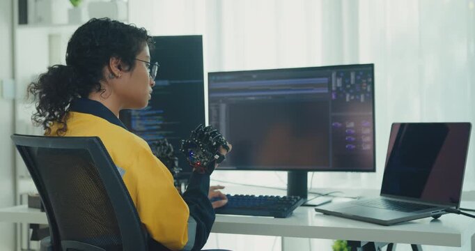 Young Black female engineer coding AI robot arm in modern laboratory. Robotics, artificial intelligence, technology, stem, future, innovation, diversity, automation, machine learning concept.