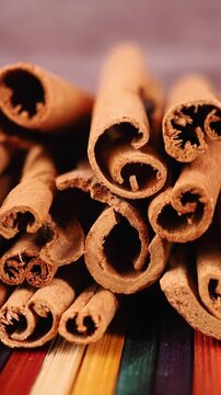 Cinnamon sticks on a colorful wooden surface