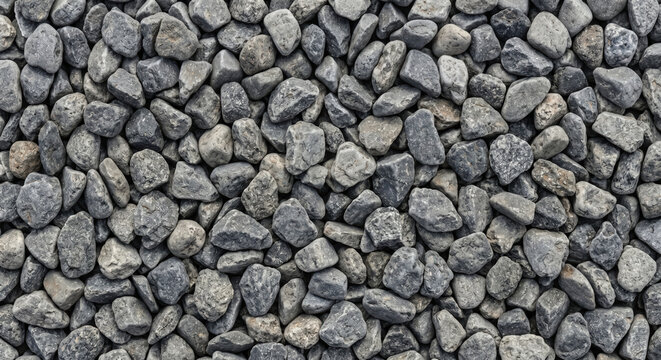 Seamless pattern of small grey and white rough gravel stones and pebbles filling the frame creating a textured natural surface for construction or landscaping
