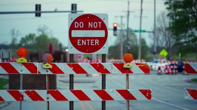Blocked road with barricades and warning sign DO NOT ENTER at dusk showing restricted access and construction area. Wide view Close up