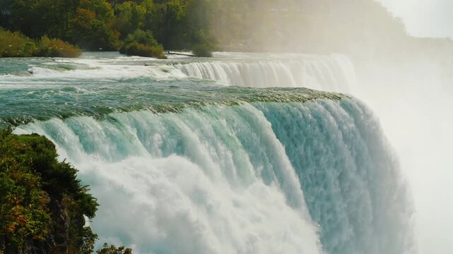Stunning cinematic view of powerful Niagara falls cascading over limestone ledge into mist.