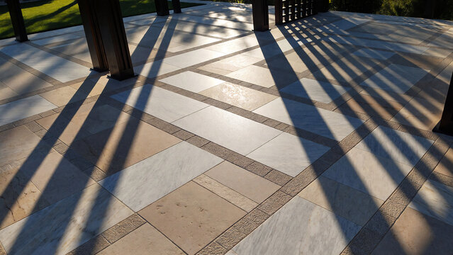 Close-up of pergola casting linear shadows on a premium terrace floor, geometric patterns, warm sunlight, luxury backyard design