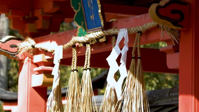 Traditional Vermilion Shinto Shrine Gate with Sacred Shimenawa Rope in Kyoto Japan