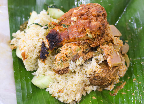 A hearty serving of Nasi Padang presented on a traditional banana leaf.