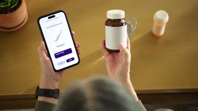Senior woman holding smartphone with medication reminder and pills, highlighting digital health, medication management, and independent living. Reflects mHealth, routine, senior care, and wellbeing.