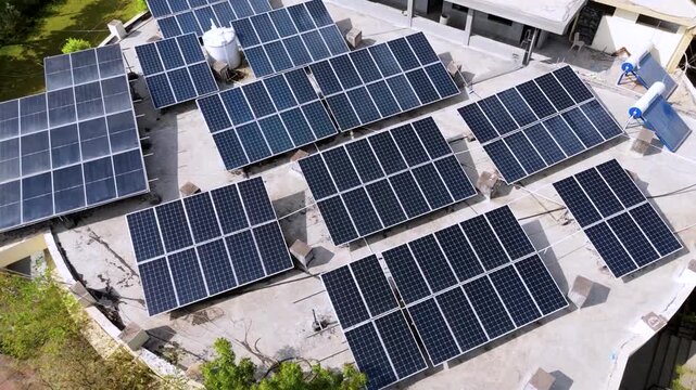 An aerial view of a modern rooftop solar power system installed on a large building. Multiple photovoltaic solar panels are arranged efficiently across the rooftop to generate clean, renewable energy.