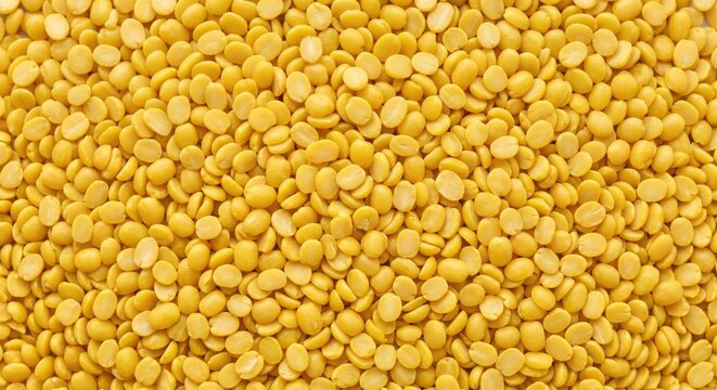 A dense pile of split yellow lentils or toor dal creating a vibrant textured background of healthy protein-rich food ingredient