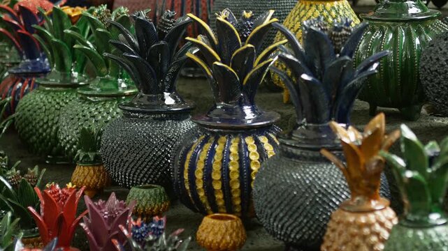 Close view of decorative pineapple ornaments with intricate patterns in artisan market