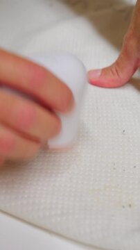 Hands using an electric lint remover, removing pilling from a white textile surface, restoring smoothness and quality to the fabric.