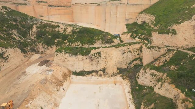 Open quarry construction site with heavy machinery and earthworks in sandy terrain, aerial
