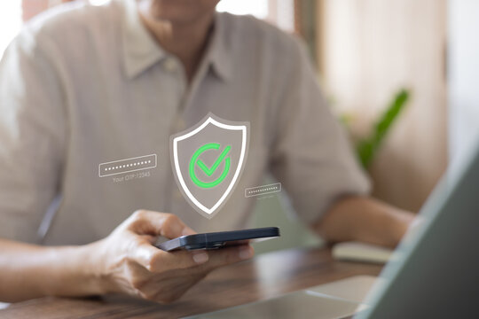Man using smartphone for online banking with glowing security shield and green checkmark hologram. Two-factor authentication and OTP login process for data protection and cybersecurity.