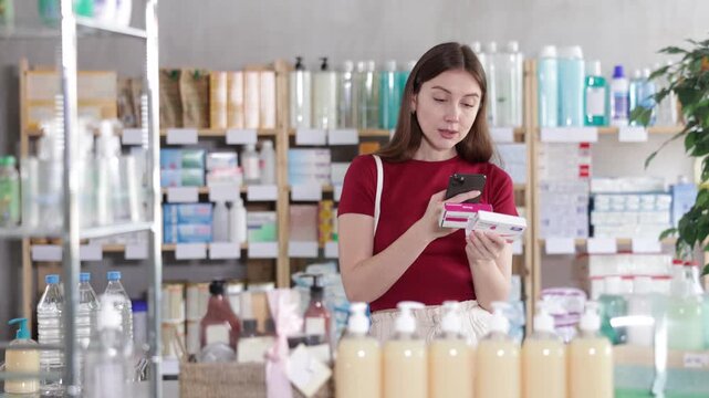 Young woman buyer scanning qr code for box of paracetamol tablets in pharmacy 