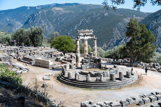 Tholos ruins at Delphi sanctuary with mountains, Greece