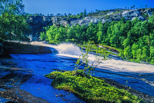 Flowing white water on a rock slab in a mountain landscape