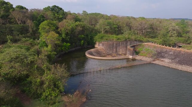 Chiklihole Reservoir dam with Chichle Canal, trees and sky at attur forest, coorg, karnataka, india. day time, trucking shot, drone shot, 4k.