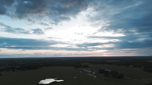 Dramatic Sky Under Poultry Houses In Industrial Farming In The Gentry, Arkansas, United States. Aerial Descending Shot