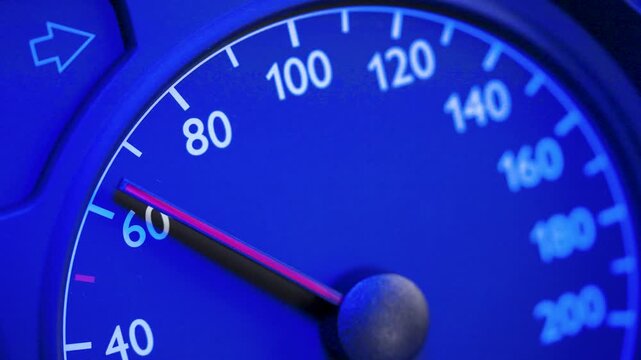 Close-up of a car speedometer showing approximately 60 kmh with a red needle and blurred blue police lights in the background. Concept image for speed control, traffic enforcement, road safety, polic