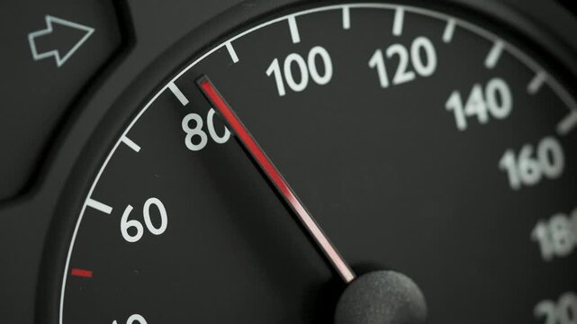 Close-up of a car speedometer with a red needle moving from 60 to 80 kmh. Concept image for acceleration, increasing speed, driving dynamics, traffic, road safety, and transportation.