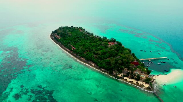 Alternate high-altitude aerial angle of Prison Island, Zanzibar showing coastline, turquoise waters and Indian Ocean. Suitable for tourism boards, travel campaigns and destination marketing.