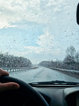 Driving through rain on a road trip with blurred view from the windshield
