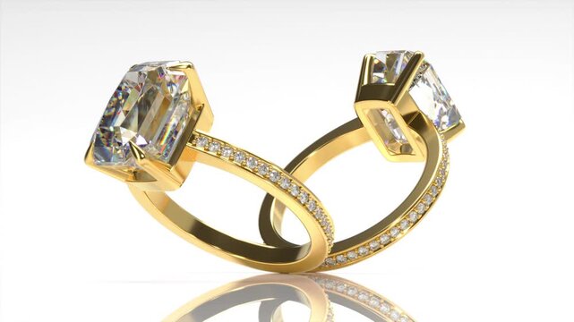 Rotation of gold ring with large emerald cut diamond and round brilliant diamonds. 3d animation on white background loop