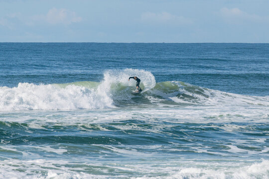 Surfer riding ocean wave during summer action sports