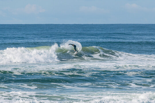 Surfer riding ocean wave during summer action sports
