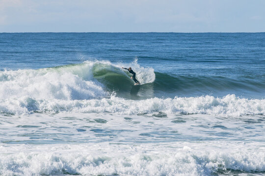 Surfer riding powerful blue ocean wave barrel