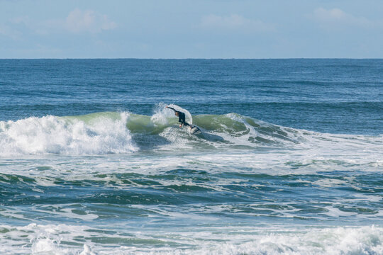 Surfer riding ocean wave during summer action sports