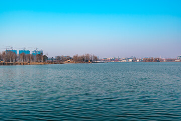 Fototapeta premium Hailong Lake Scenic Area in Meihekou – Ecological Wetland and Urban Park Landscape with Lakeside Recreation, Commercial Street and Public Leisure Spaces, China – April 2, 2026