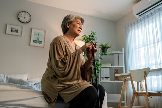 Asian senior elderly depressed woman sitting alone in bedroom at home. 