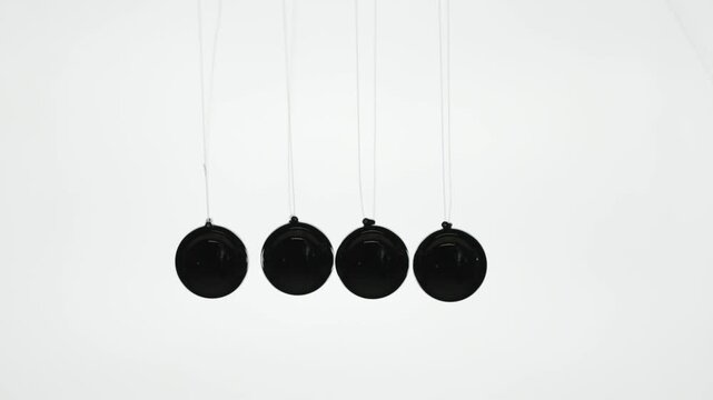 Newtons cradle kinetic energy motion, dynamic physics experiment with black balls on white background, seamless loop.