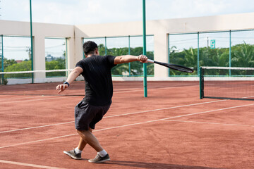 Fototapeta premium Asian young sportsman exercise, playing tennis on outdoor clay court. 