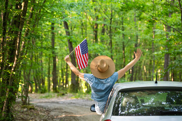 Woman in the car holding a waving american USA flag. © erika8213