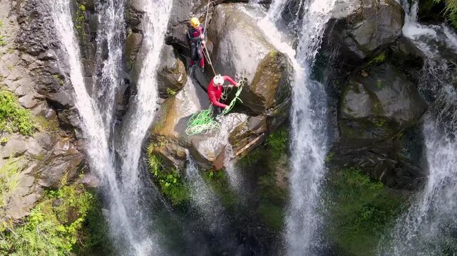 Adventurous People Canyoneering Down a Scenic Tropical Waterfall