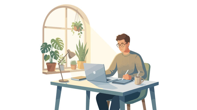 A man sitting at a desk working on a laptop computer.