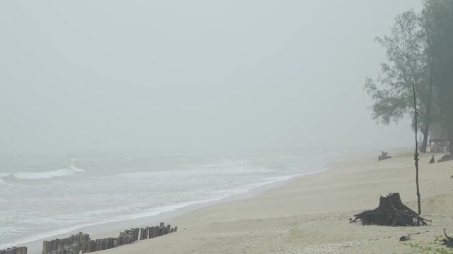 climate change concept view of heavy storm and wind blowing white sand beach with huge wave in sea hit the sand beach in daytime, storming weather landscape at beach