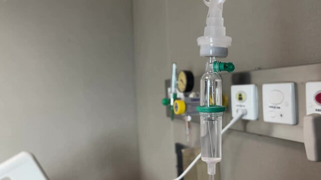 A close-up view of an IV drip and drip chamber containing lactated Ringer's solution in a hospital. Medical equipment for patient hydration and treatment, symbolizing patient health care.