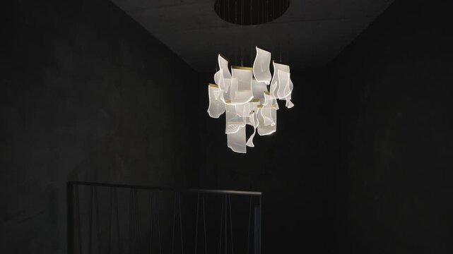 Camera slowly entering a dark room to reveal a contemporary designer led lamp hanging from the ceiling