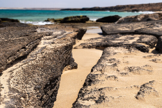 The beautiful white sandy beach with the unique sandscaped boulders on the waterfront of the Atlantic ocean near the village of Pedra de Luma on the island of Sal in Cape Verde. This kind of deserted 