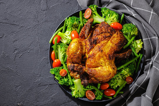 whole roasted chicken with veggies on a plate