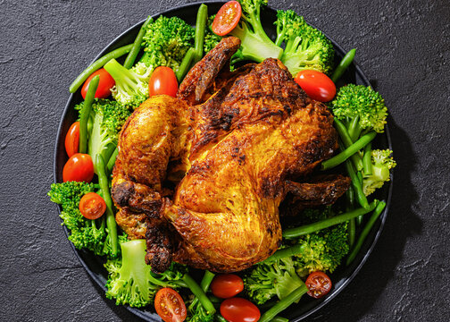whole roasted chicken with veggies on a plate