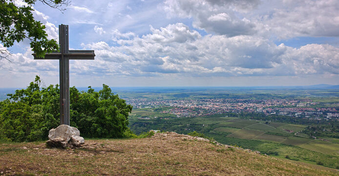 Large cross made from railway rails overlooking Eger and the B&uuml;kk foothills under dramatic spring clouds on Nagy-Eged Hill, Hungary.