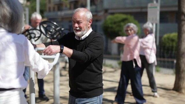 Elderly men and women gather in courtyard, using outdoor gym equipment for fitness