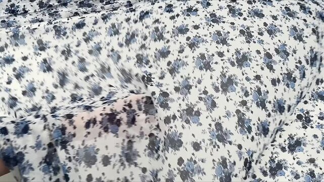 Elegant semi transparent textile featuring a delicate ditsy floral pattern with blue and navy roses on a white base perfect for airy summer dresses feminine blouses and creative dressmaking projects